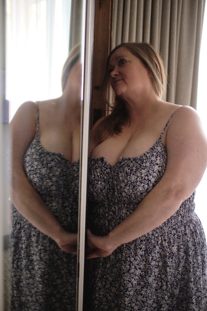 Gracie in a floral dress by a mirror